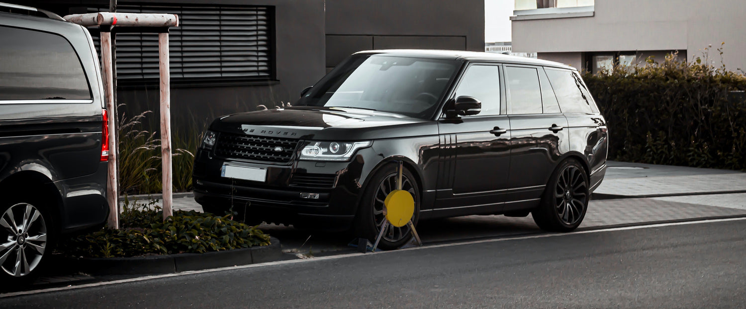 Parkkralle an einem schwarzen Range Rover Sport im Wohngebiet als Diebstahlschutz